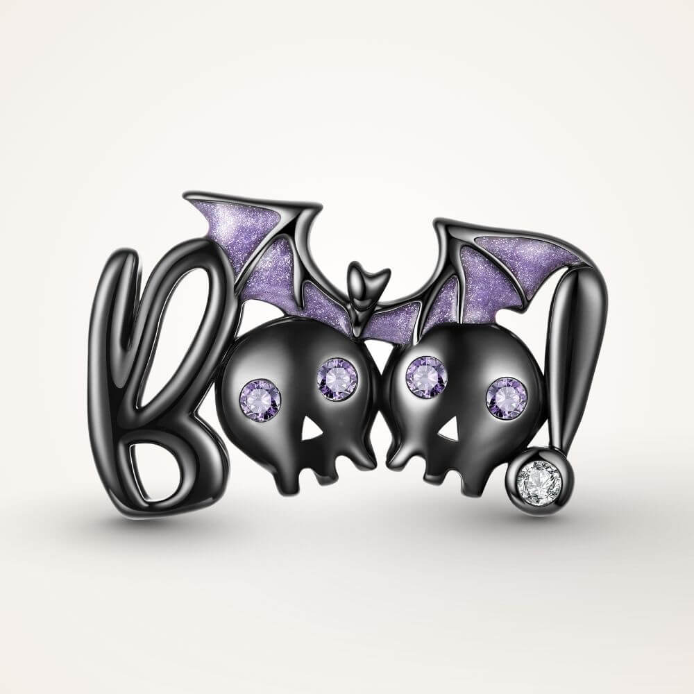 Black skull and bat charm with purple crystal eyes, glitter wings, and playful spooky Halloween details - ORÉYA