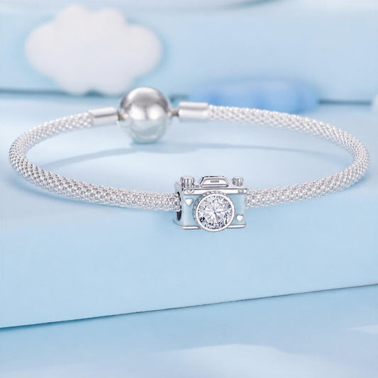 Sterling silver camera charm with blue enamel, heart details, and crystal lens.