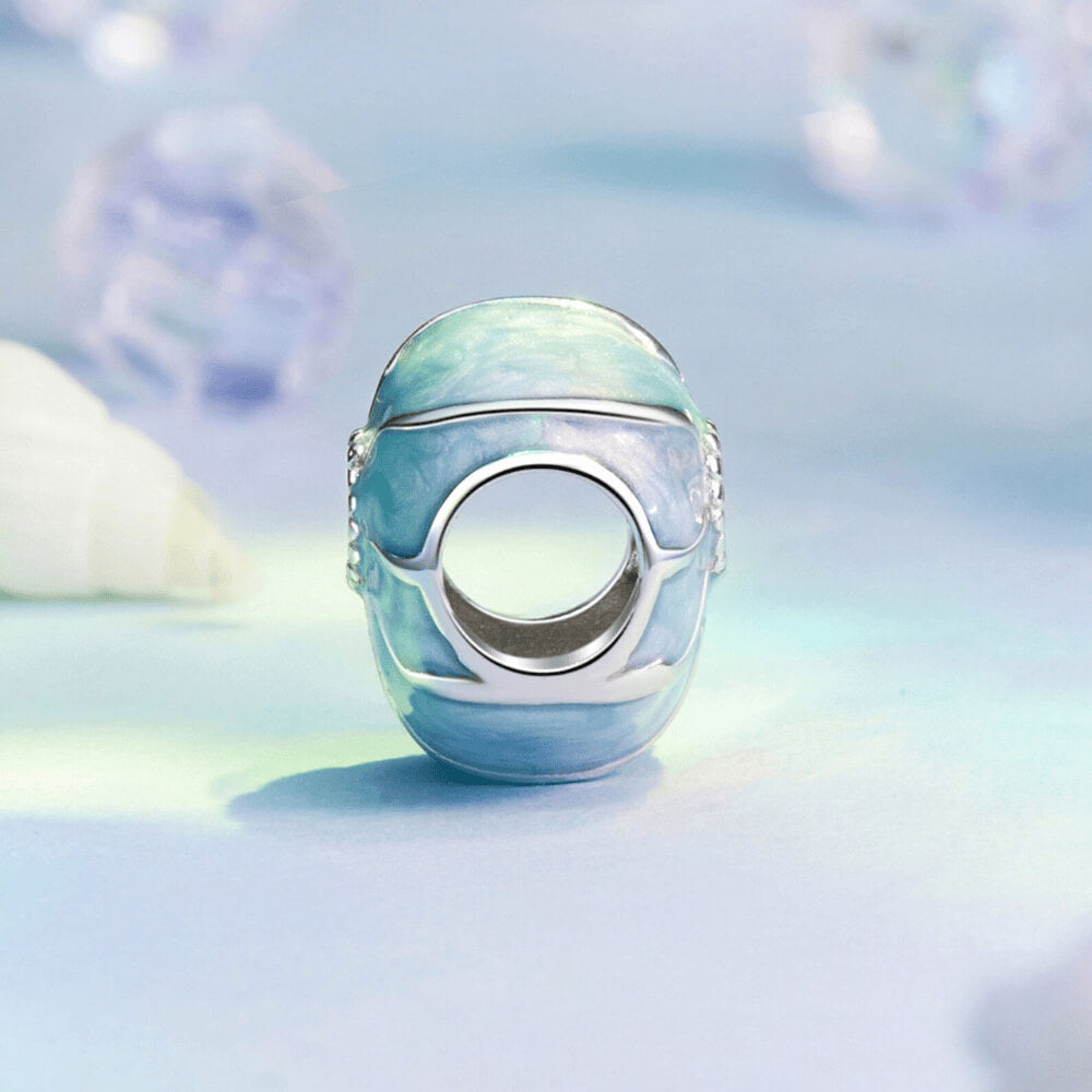 Sterling silver bead charm with blue enamel shell design and central clear gemstone.