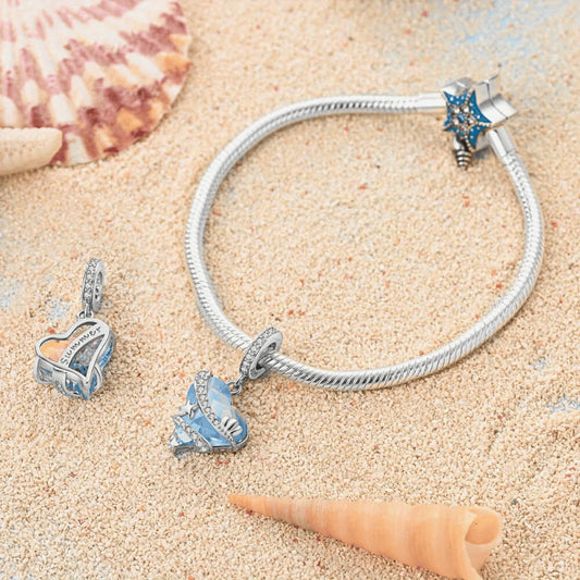 Sterling silver heart charm with blue faceted crystal and sea-themed details.