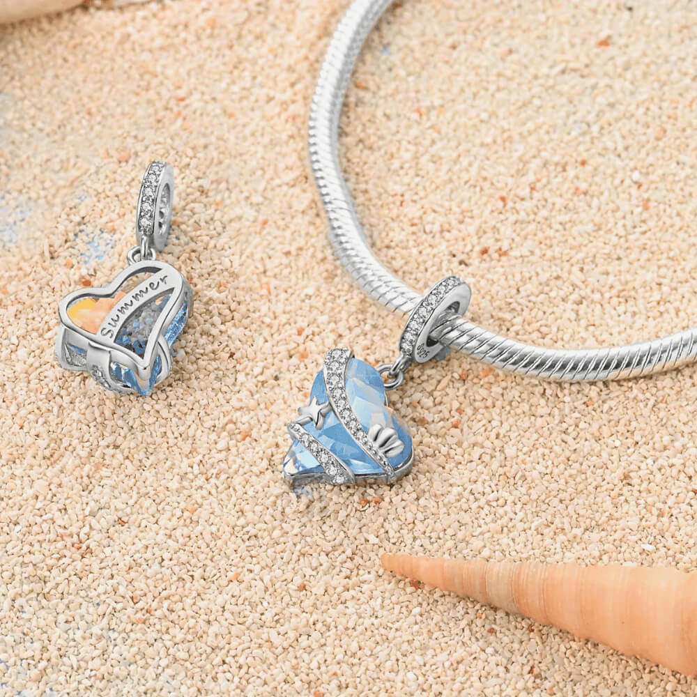 Sterling silver heart charm with blue faceted crystal and sea-themed details.