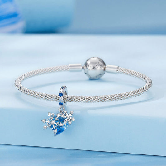 Sterling silver snowflake charm with blue heart crystal and blue gemstone bail.