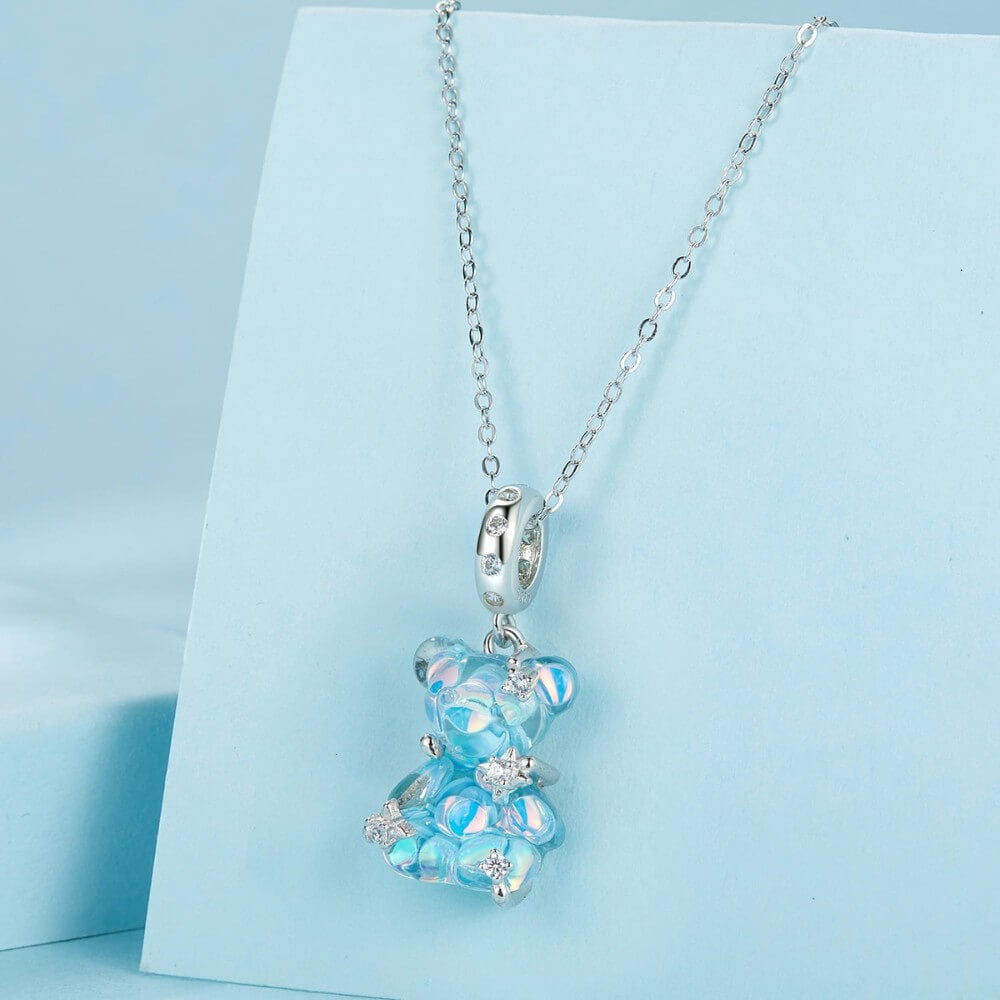 Blue teddy bear charm with iridescent finish and sparkling star details.