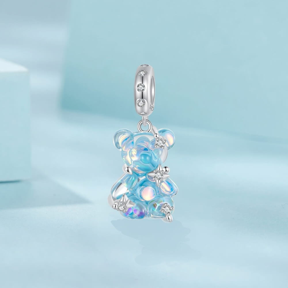 Blue teddy bear charm with iridescent finish and sparkling star details.