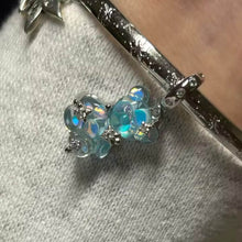 Blue teddy bear charm with iridescent finish and sparkling star details.