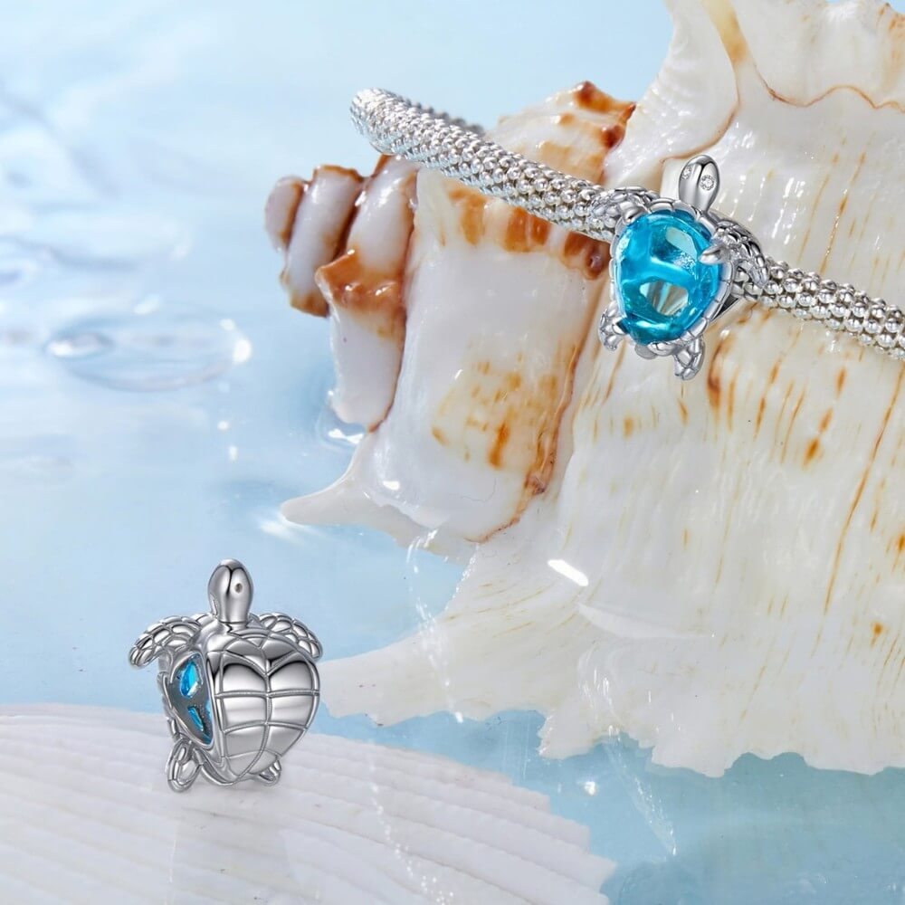 Sterling silver sea turtle charm with blue crystal shell and detailed flippers.