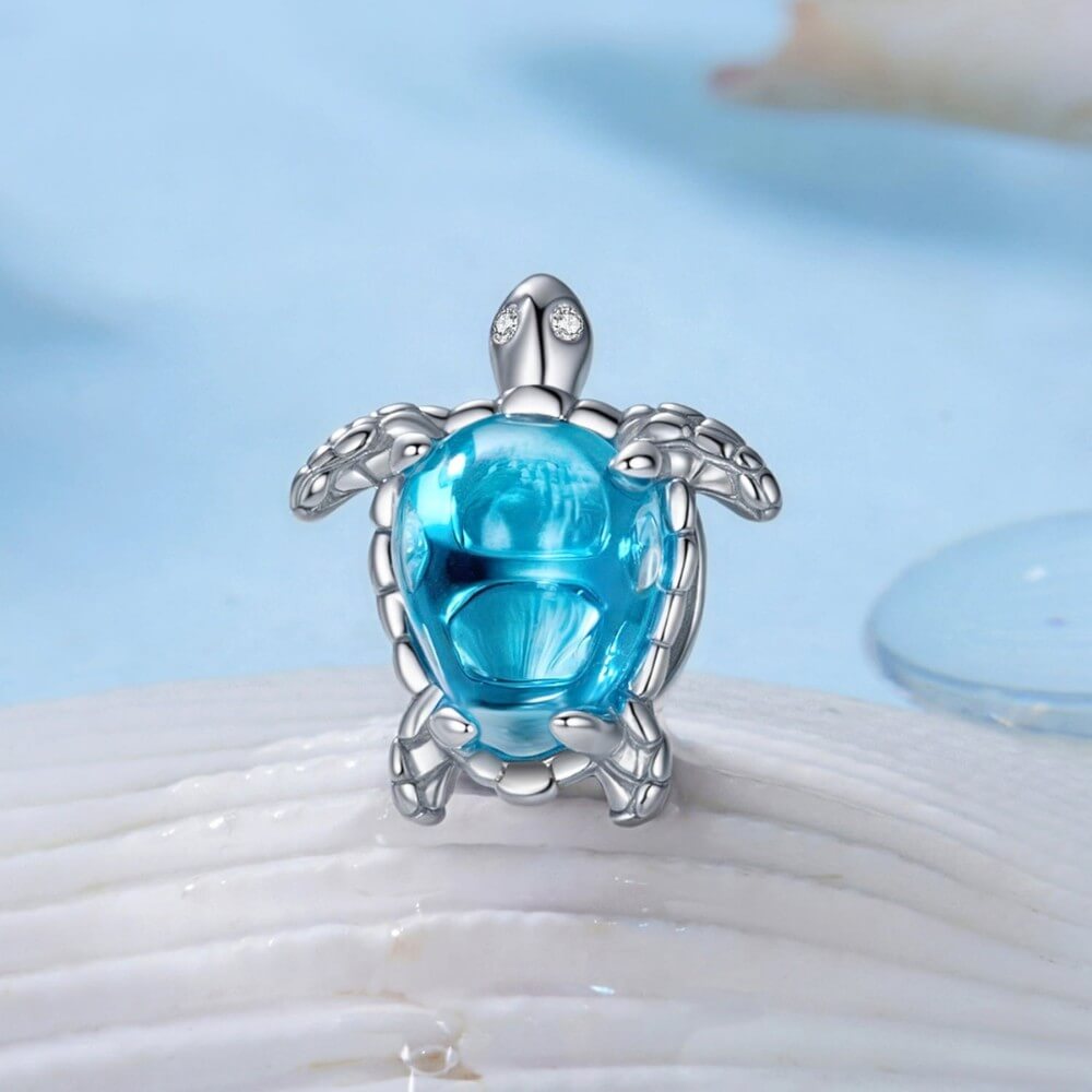 Sterling silver sea turtle charm with blue crystal shell and detailed flippers.