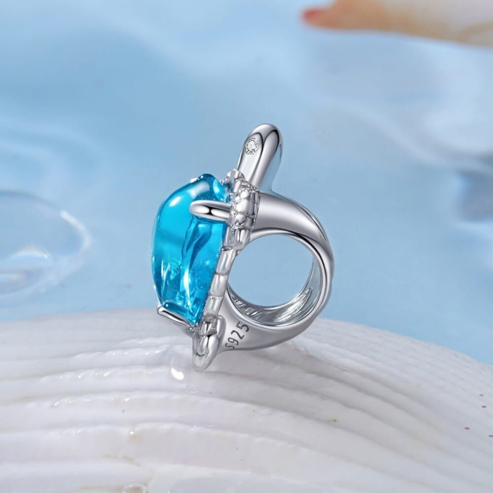 Sterling silver sea turtle charm with blue crystal shell and detailed flippers.