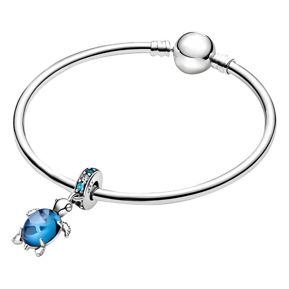 Sterling silver sea turtle charm with blue faceted shell and blue gemstone bail.