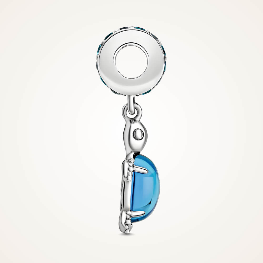 Sterling silver sea turtle charm with blue faceted shell and blue gemstone bail.