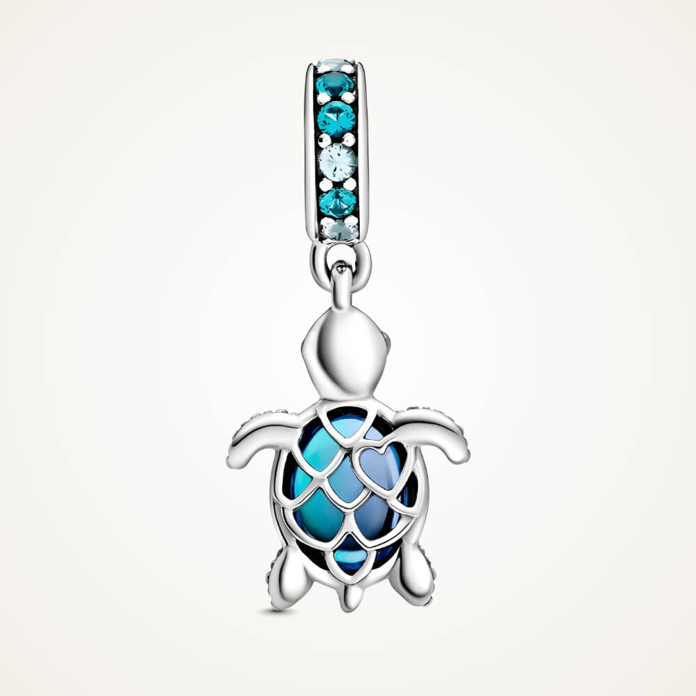 Sterling silver sea turtle charm with blue faceted shell and blue gemstone bail.