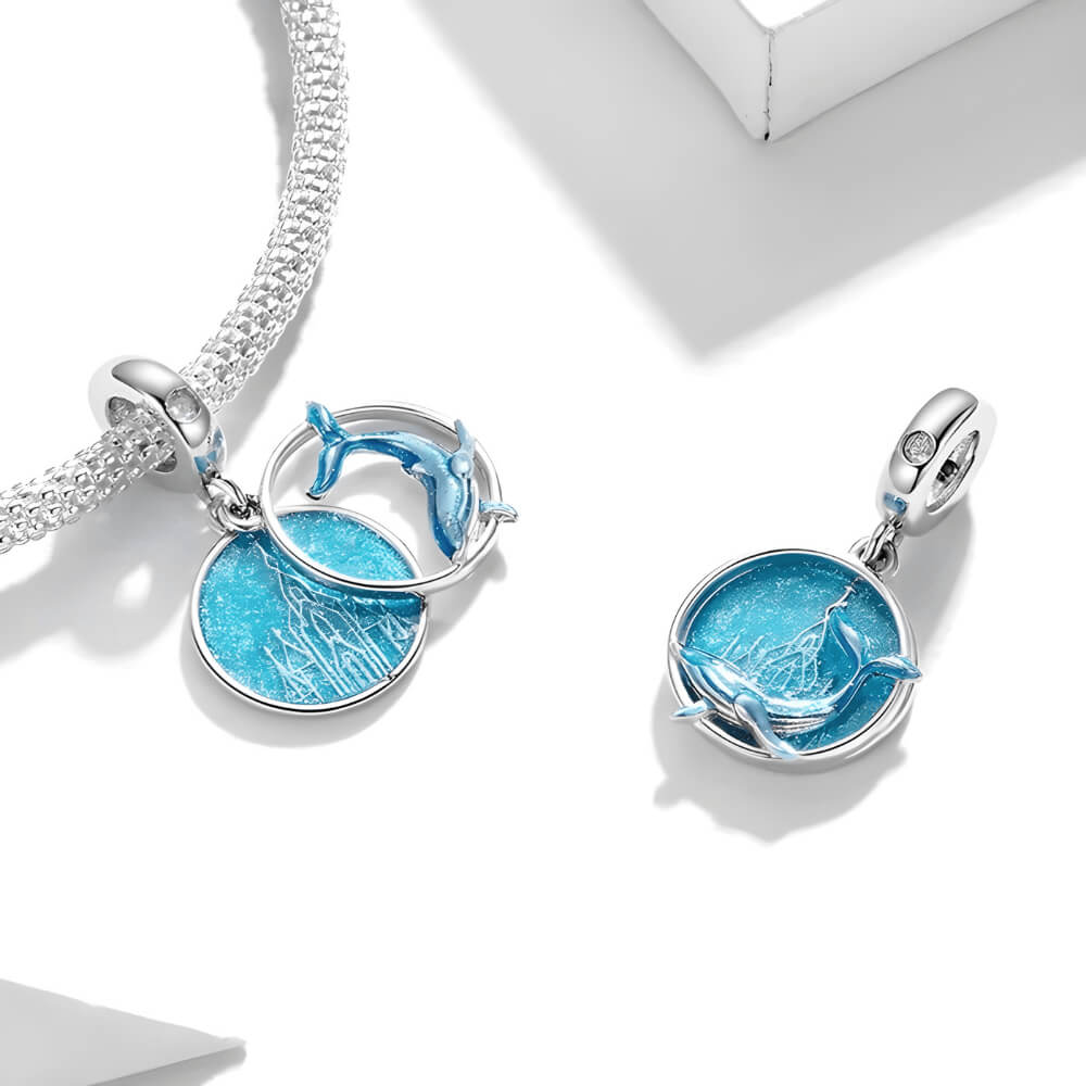 Sterling silver double dangle charm with blue whale design and glittery round disc.