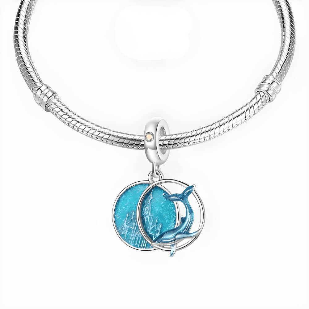 Sterling silver double dangle charm with blue whale design and glittery round disc.