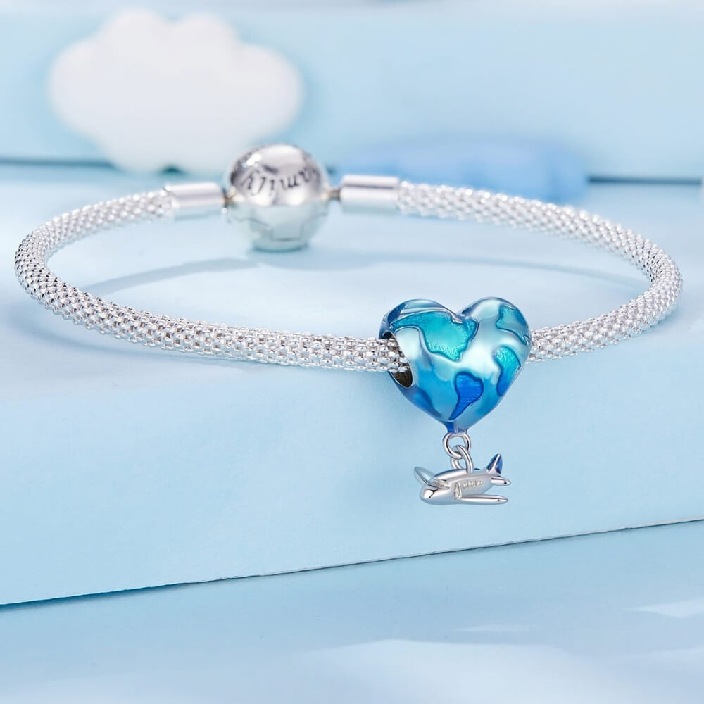 Silver bracelet with a blue heart-shaped charm on a light blue background