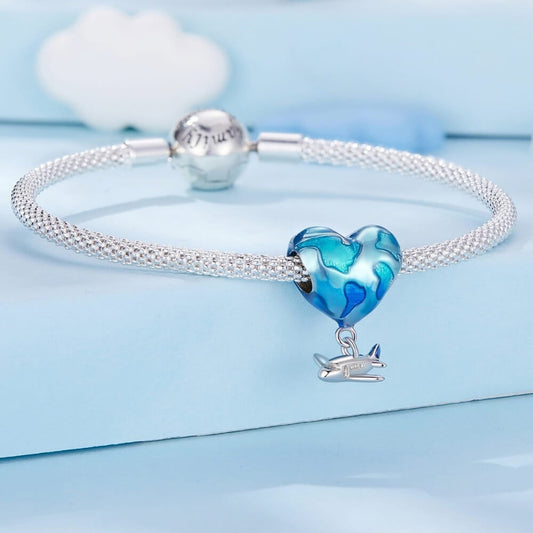 Silver bracelet with a blue heart-shaped charm on a light blue background
