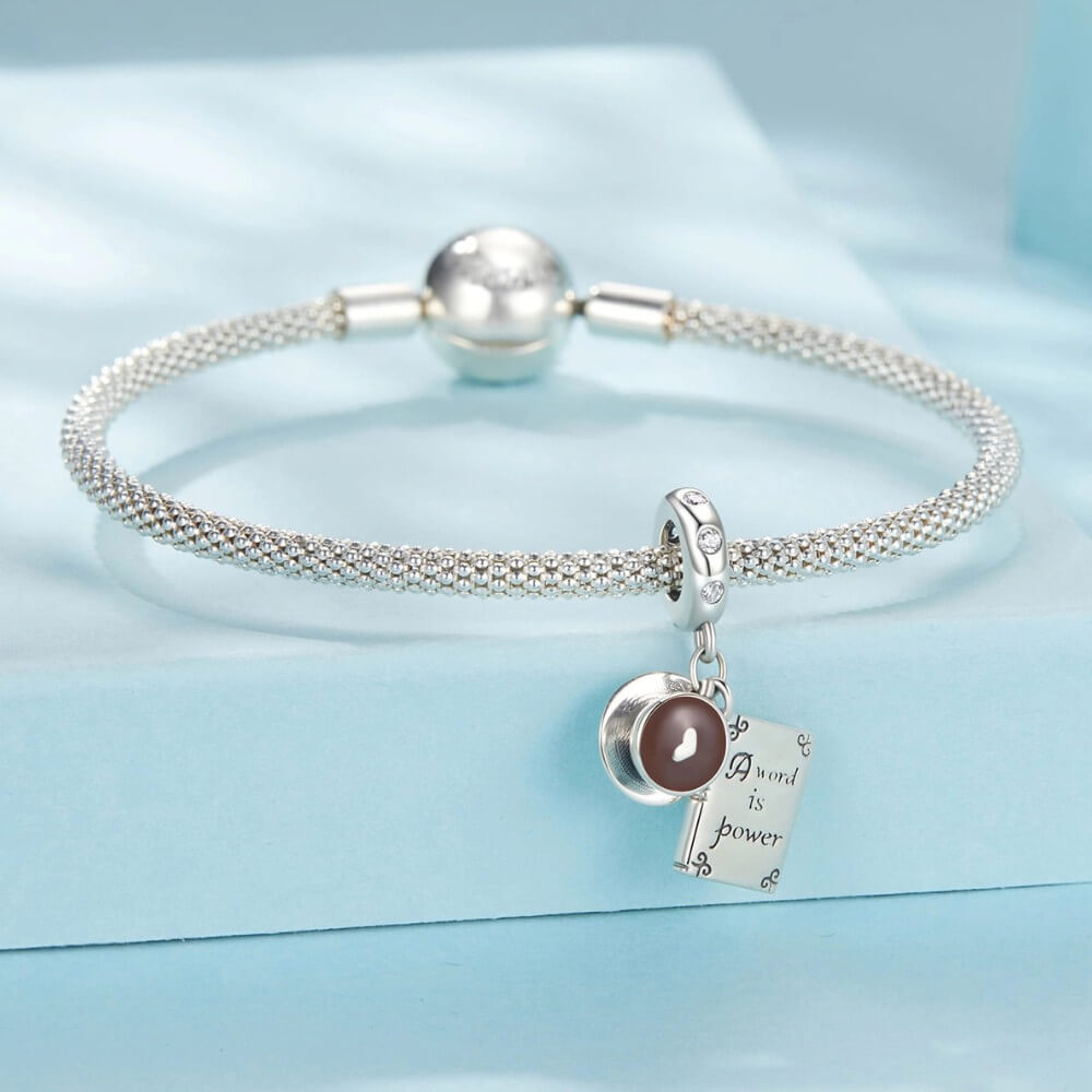 Sterling silver book and coffee charm with engraved inspirational quote.