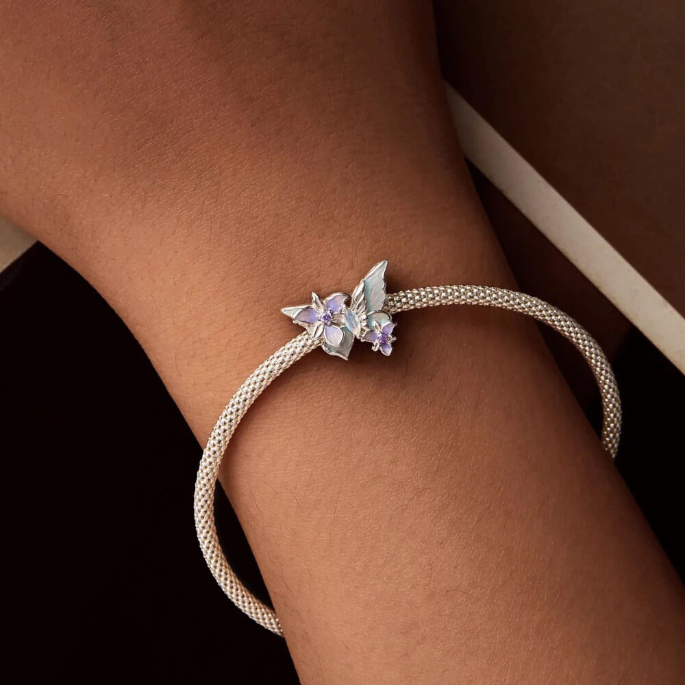 Sterling silver butterfly charm with pastel enamel flowers and crystal center.