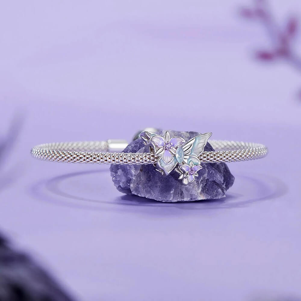 Sterling silver butterfly charm with pastel enamel flowers and crystal center.