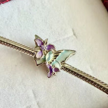 Sterling silver butterfly charm with pastel enamel flowers and crystal center.