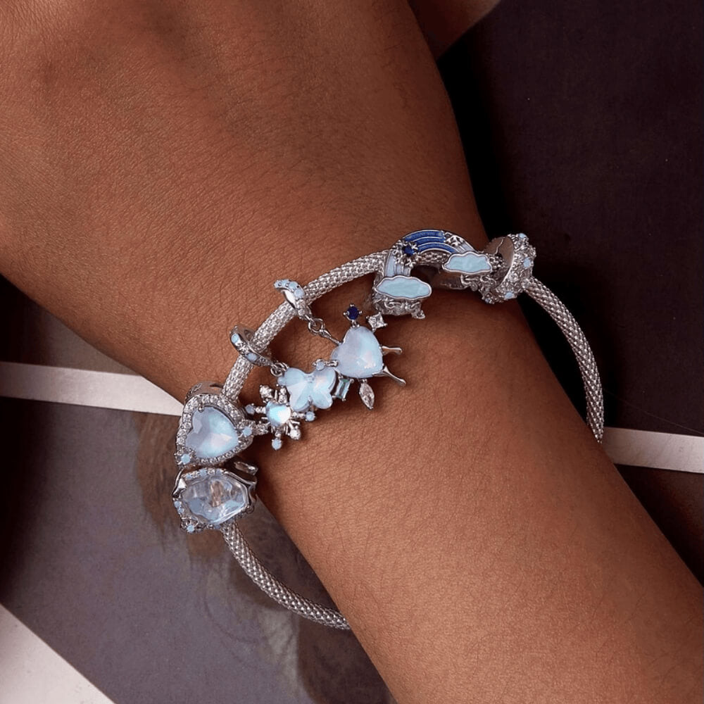 Sterling silver double dangle charm with opal-like butterfly, snowflake, and light blue accents.
