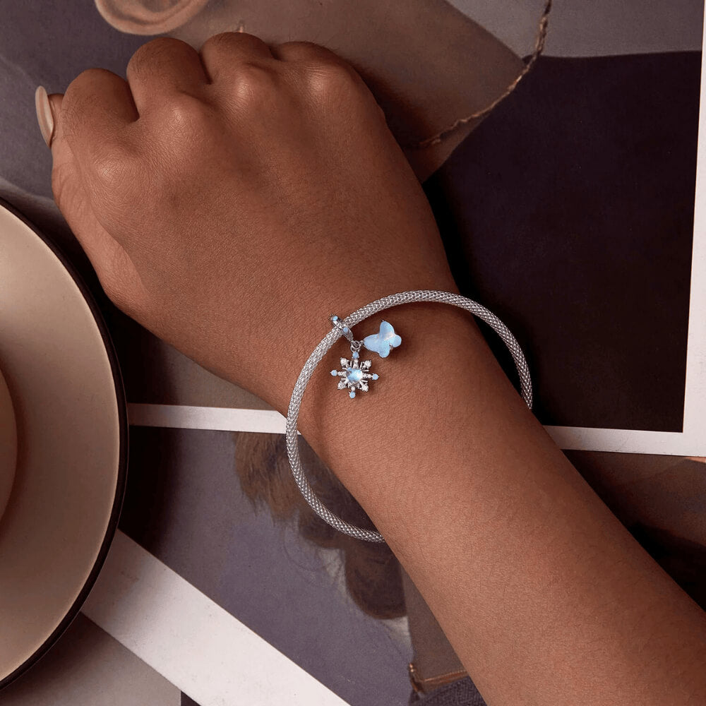 Sterling silver double dangle charm with opal-like butterfly, snowflake, and light blue accents.