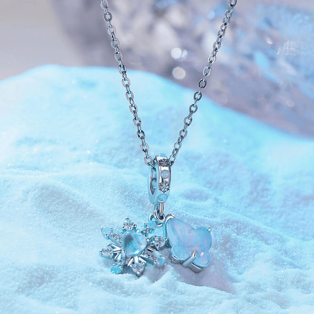 Sterling silver double dangle charm with opal-like butterfly, snowflake, and light blue accents.