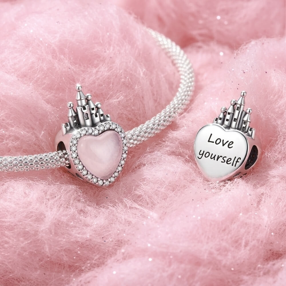 Sterling silver castle charm with pink heart center and crystal border.