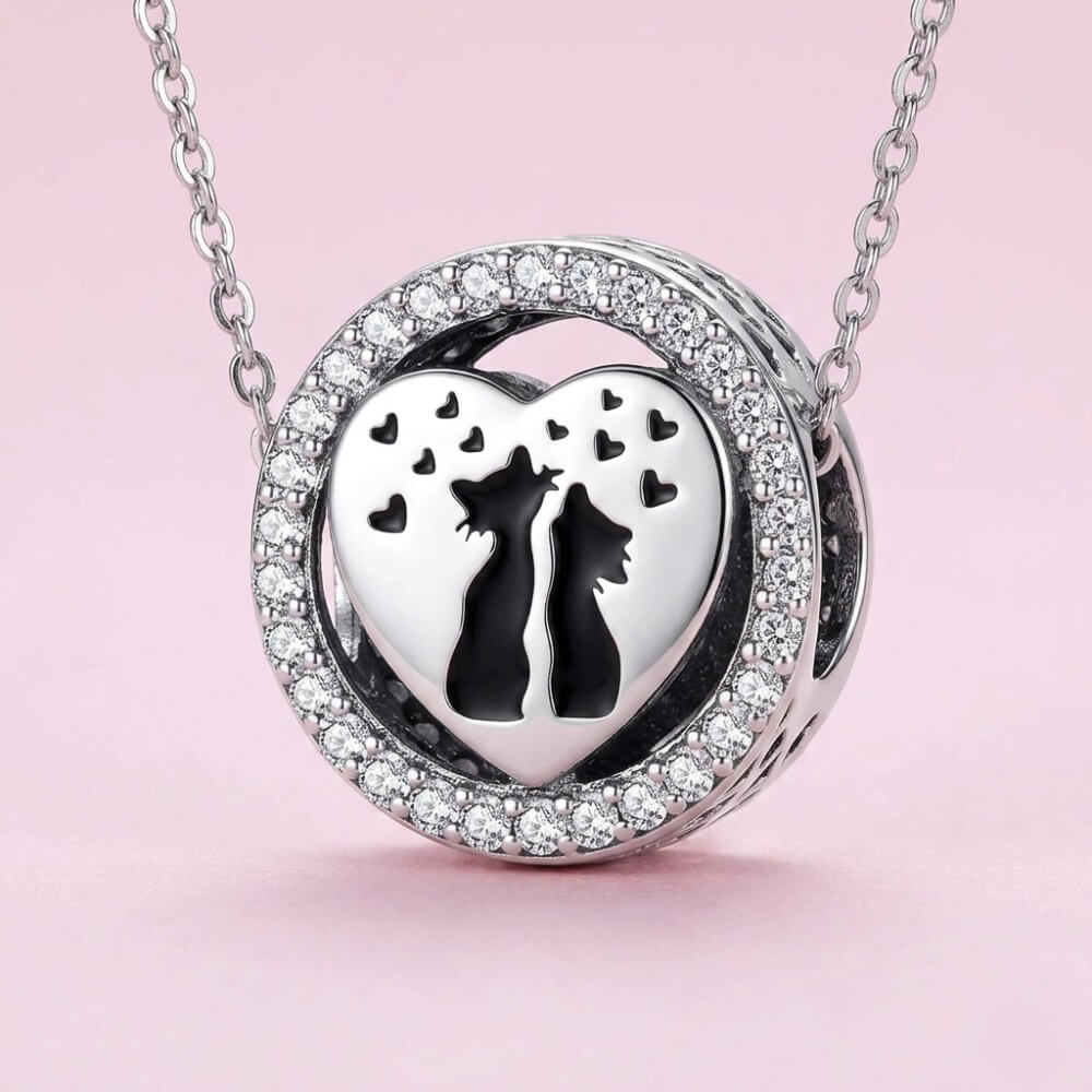 Sterling silver cat heart charm with crystal border and black silhouettes.