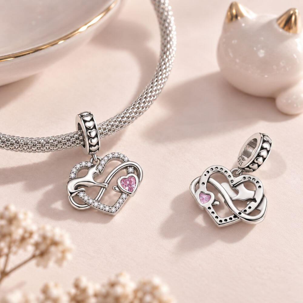 Sterling silver cat heart charm with infinity design, sparkling crystals, and a pink heart stone accent.