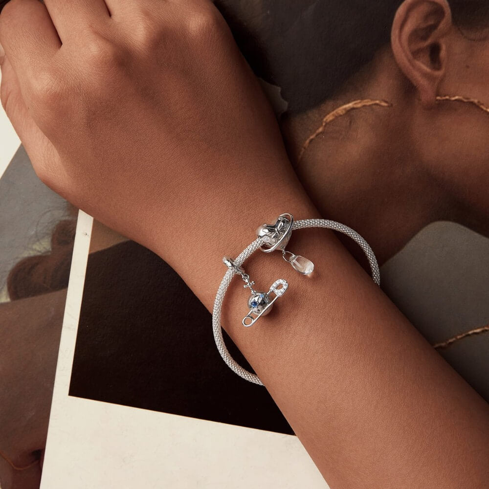 Sterling silver safety pin charm with stars, crystals, and celestial details.
