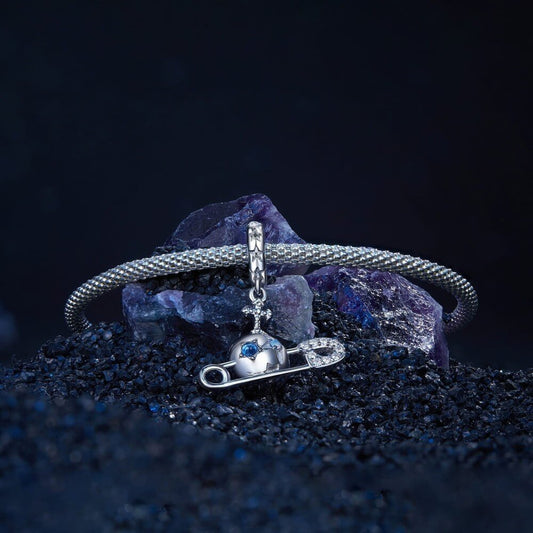Sterling silver safety pin charm with stars, crystals, and celestial details.