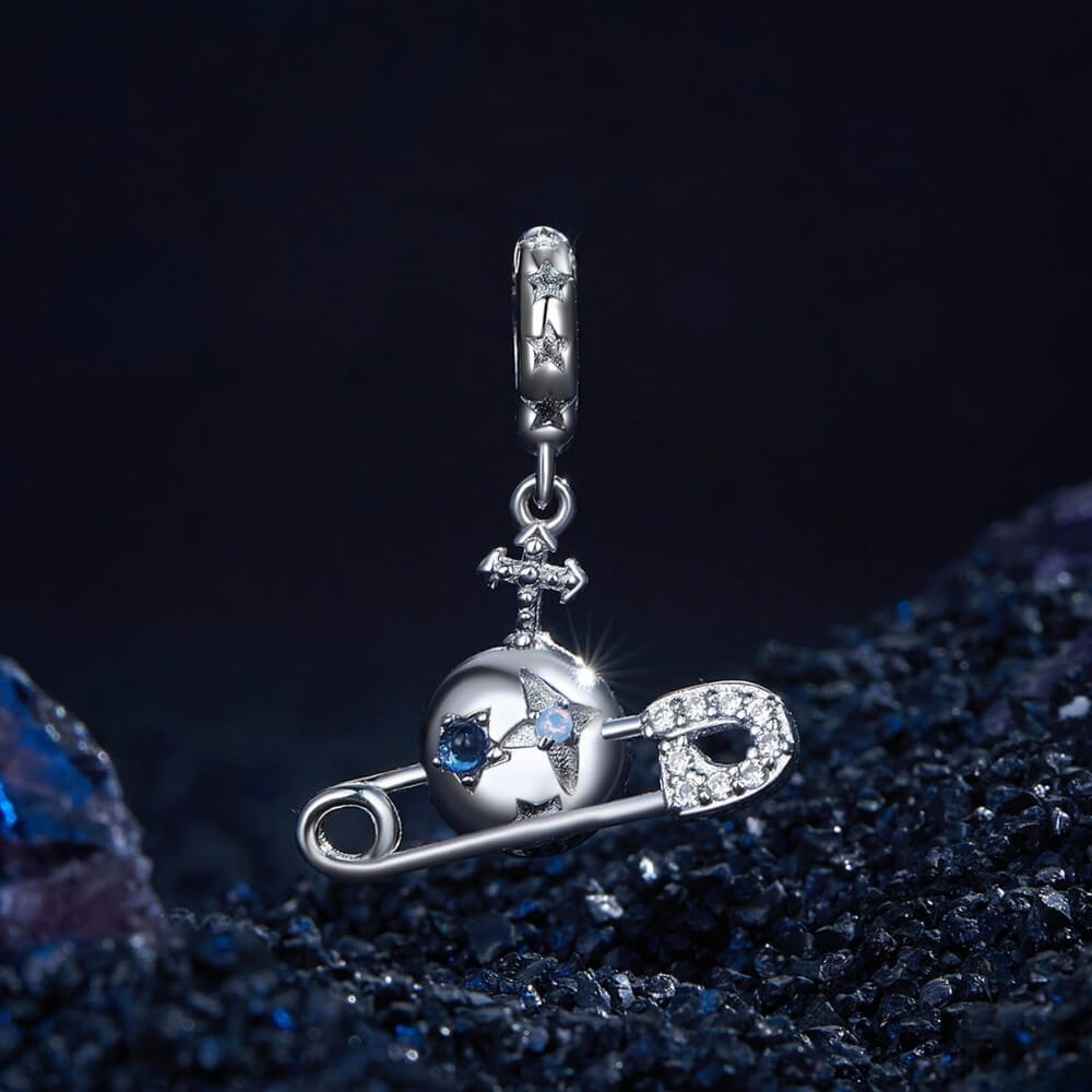 Sterling silver safety pin charm with stars, crystals, and celestial details.