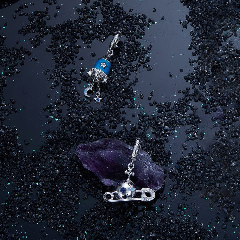 Sterling silver safety pin charm with stars, crystals, and celestial details.
