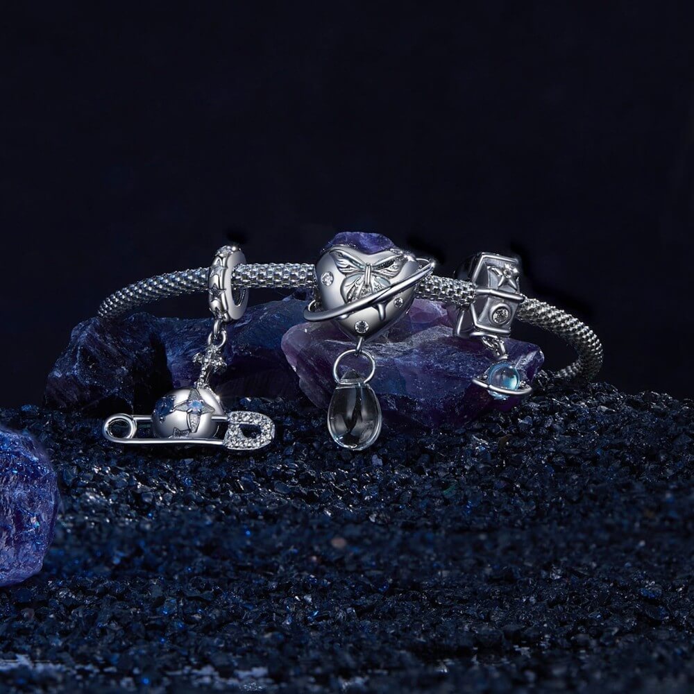 Sterling silver safety pin charm with stars, crystals, and celestial details.