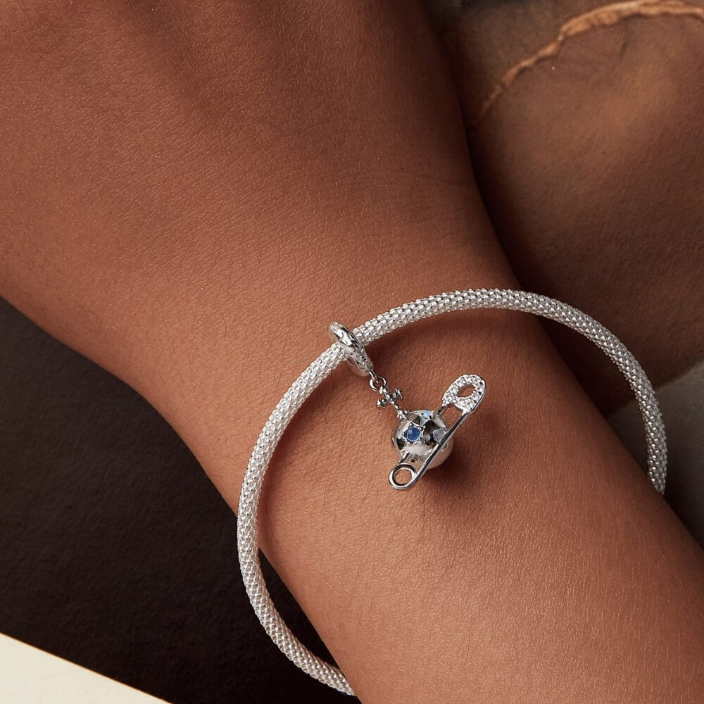 Sterling silver safety pin charm with stars, crystals, and celestial details.