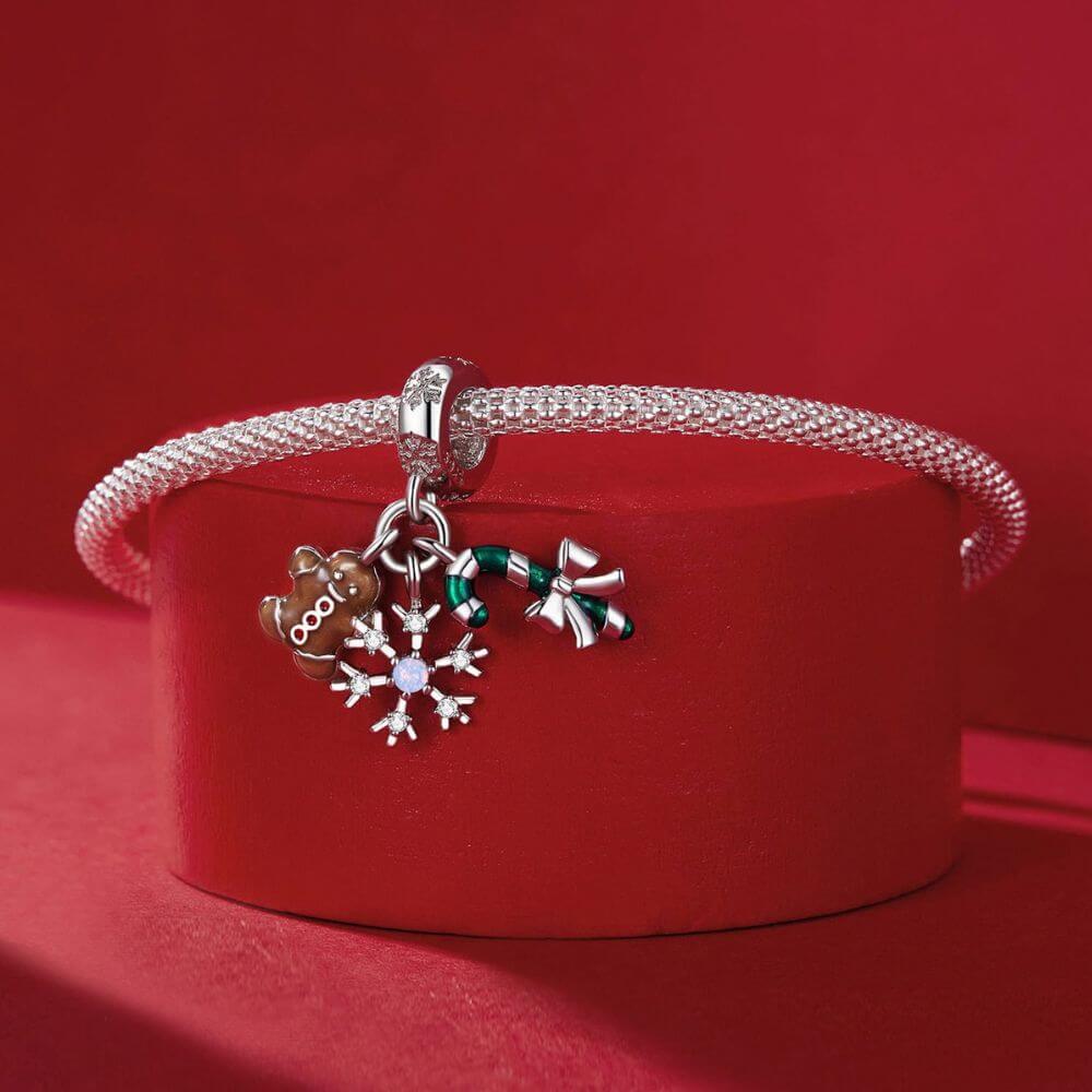 Sterling silver Christmas charm with gingerbread man, candy cane, bow, snowflake, and sparkling crystal details.