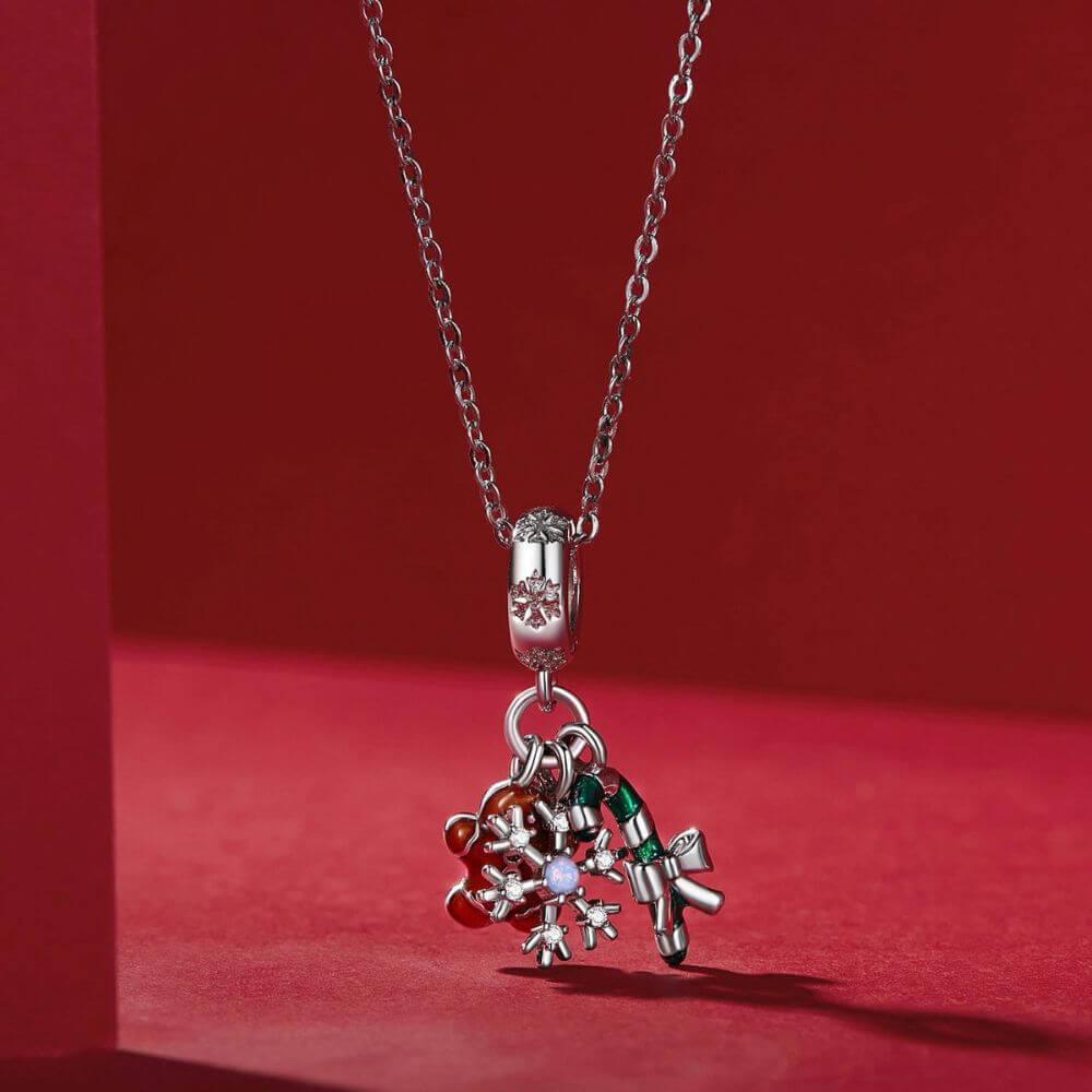 Sterling silver Christmas charm with gingerbread man, candy cane, bow, snowflake, and sparkling crystal details.