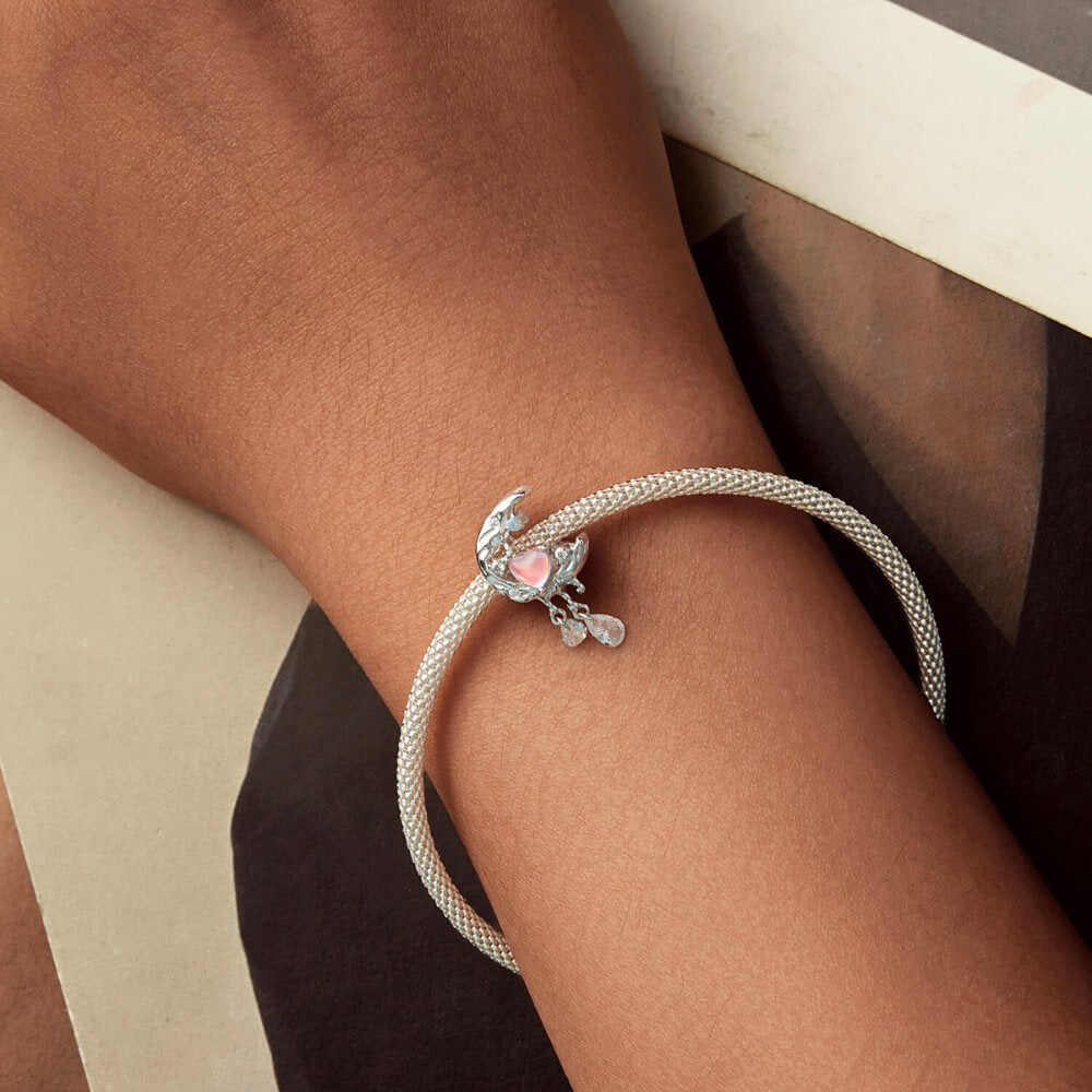 Sterling silver crescent moon charm with opal heart, clear gemstones, and dangling crystals.