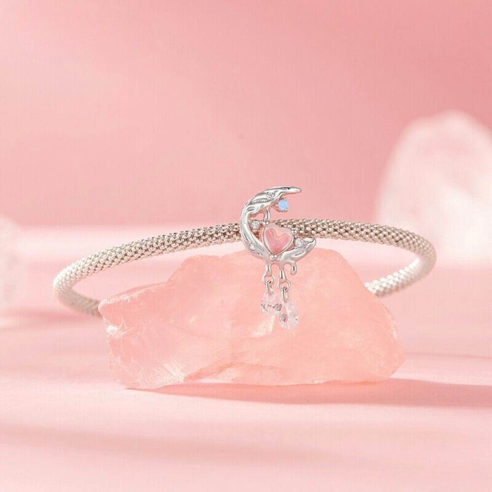 Sterling silver crescent moon charm with opal heart, clear gemstones, and dangling crystals.