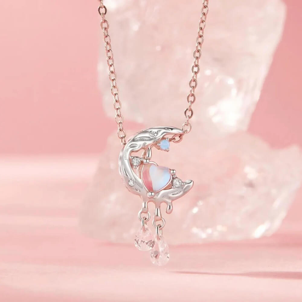 Sterling silver crescent moon charm with opal heart, clear gemstones, and dangling crystals.
