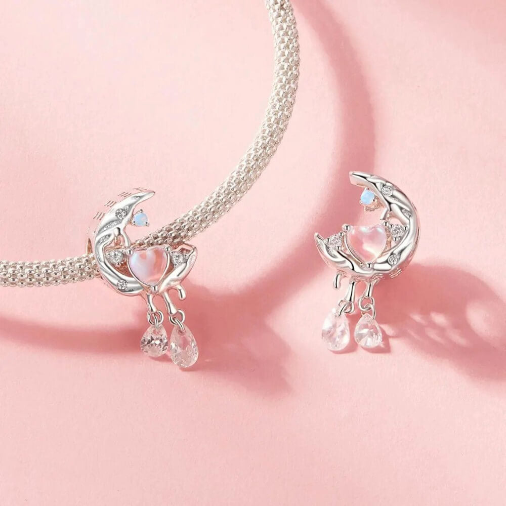 Sterling silver crescent moon charm with opal heart, clear gemstones, and dangling crystals.