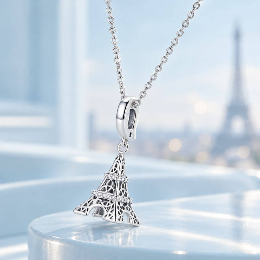 Sterling silver Eiffel Tower charm with sparkling crystal bands and detailed Paris landmark design.