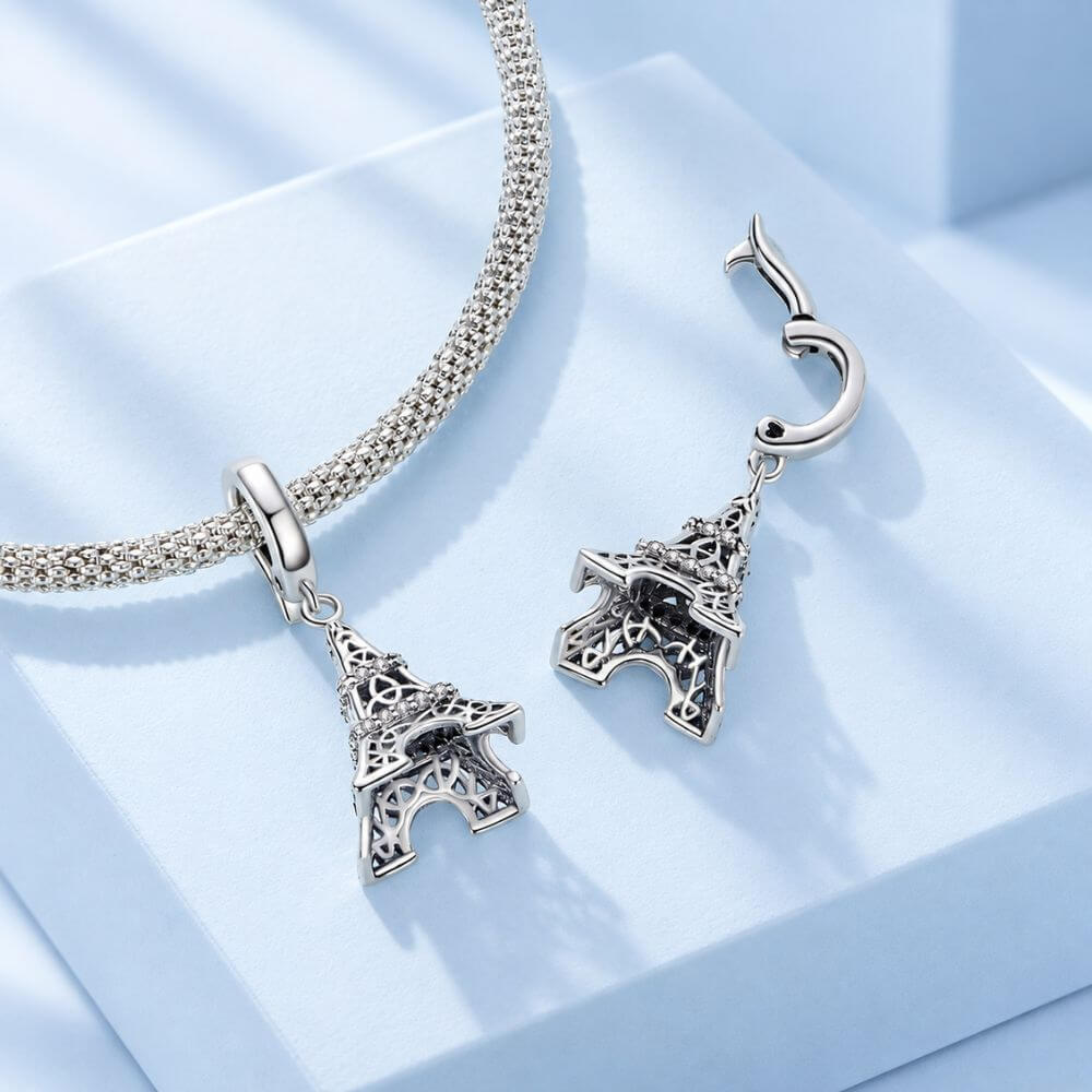 Sterling silver Eiffel Tower charm with sparkling crystal bands and detailed Paris landmark design.
