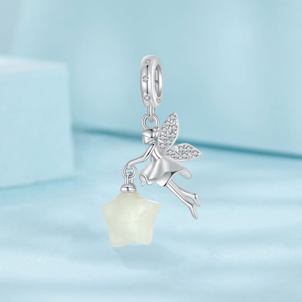 Sterling silver fairy charm holding glowing star with crystal wing details.