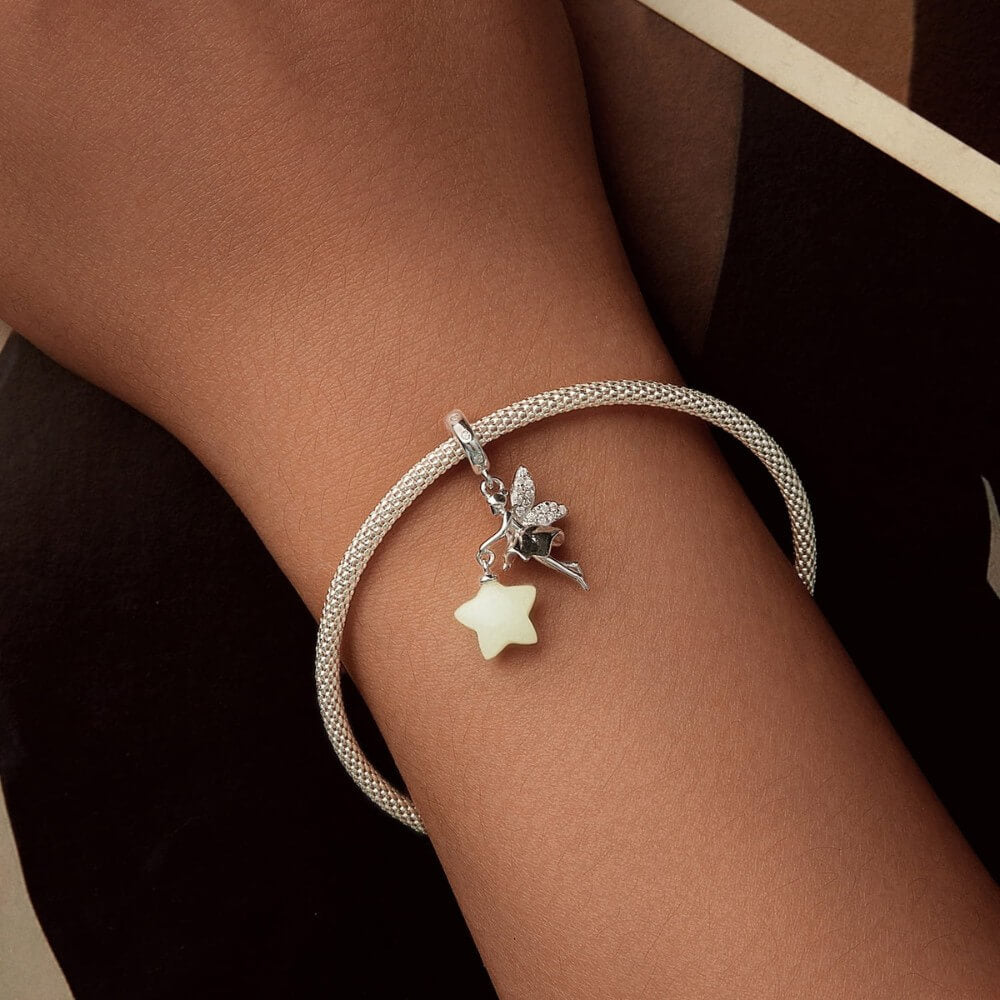 Sterling silver fairy charm holding glowing star with crystal wing details.