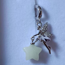 Sterling silver fairy charm holding glowing star with crystal wing details.
