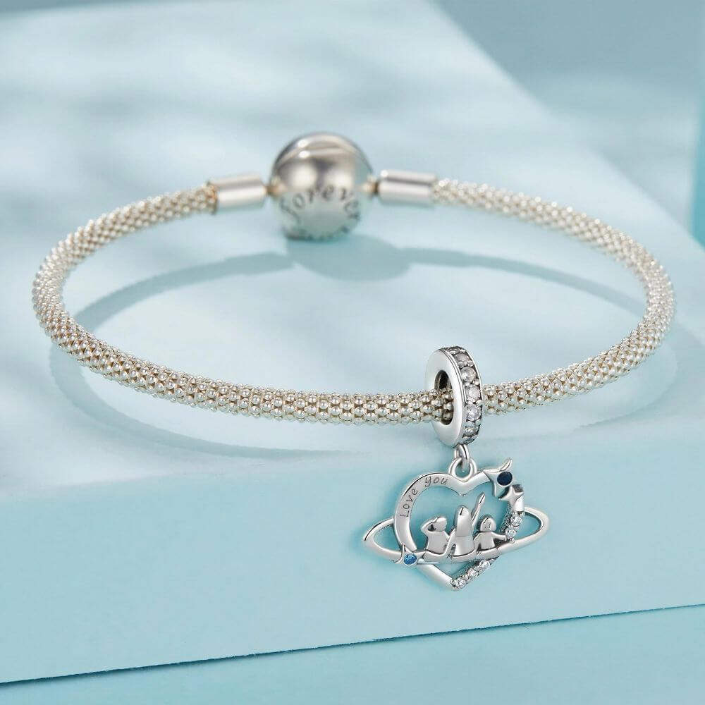 Sterling silver family heart charm with mother and children, blue crystals, stars, and orbit details.