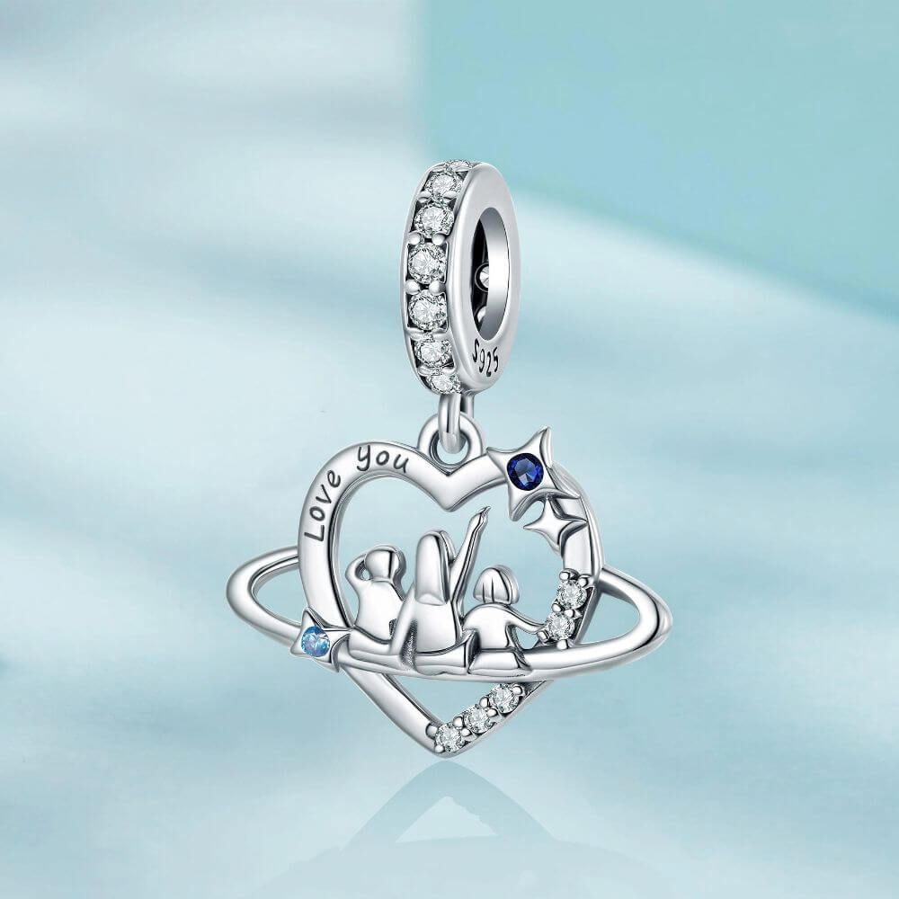 Sterling silver family heart charm with mother and children, blue crystals, stars, and orbit details.