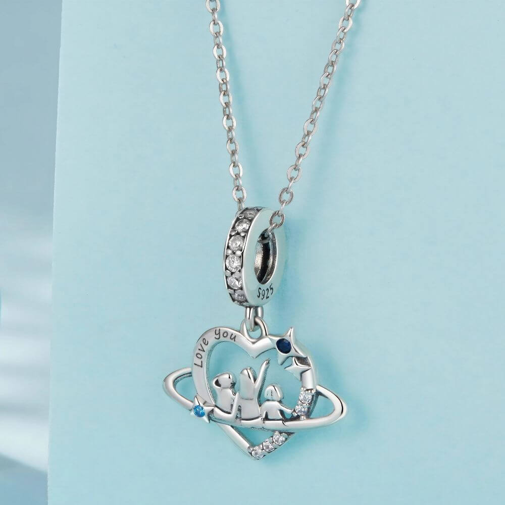 Sterling silver family heart charm with mother and children, blue crystals, stars, and orbit details.