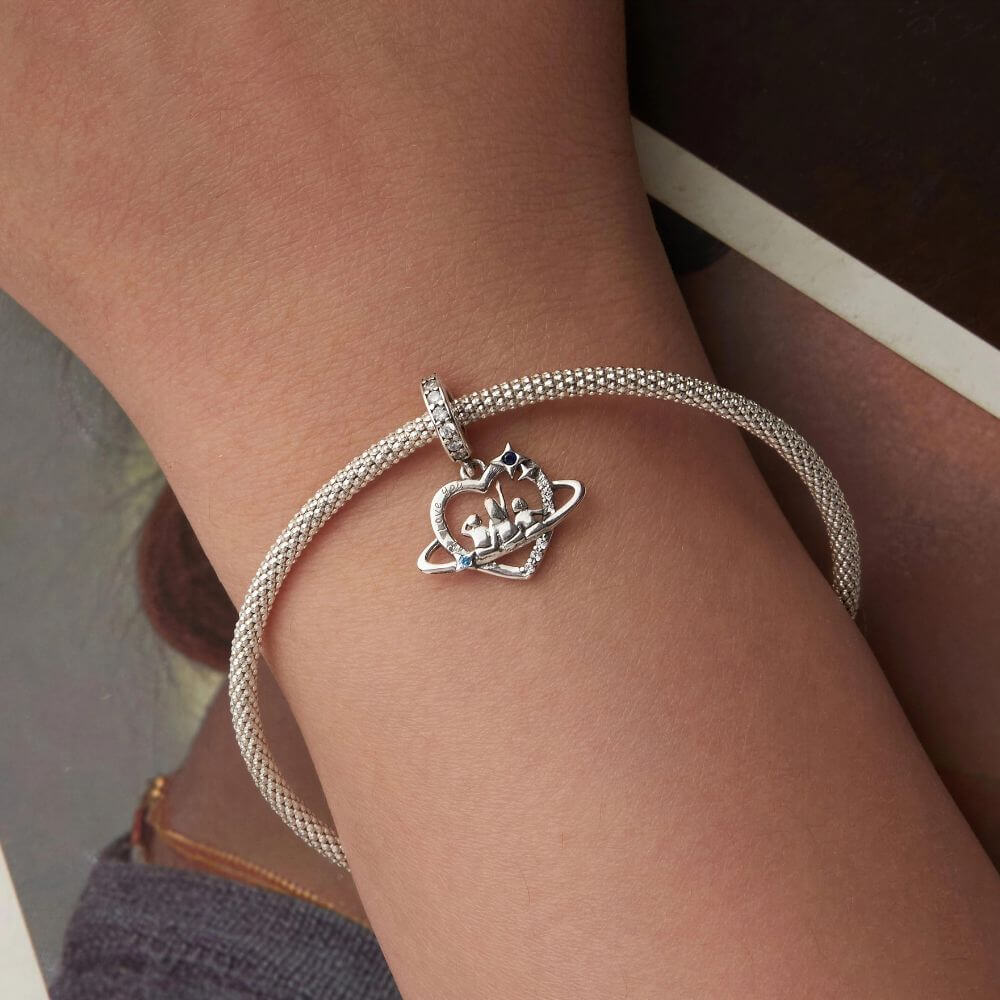 Sterling silver family heart charm with mother and children, blue crystals, stars, and orbit details.
